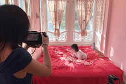 a student films another student on the bed in a very pink room