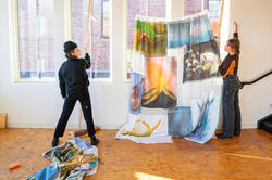 Students hang painted fabric in an illustration studio