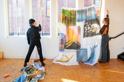 Students hang painted fabric in an illustration studio