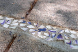 Crushed quahog shells artfully fill in a crack in the sidewalk