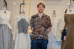 Hawk poses with works in progress on dress forms
