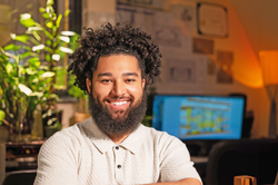 Holden Rappuhn smiles in his work space near his computer