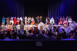 all of the student designers and models on stage for a last bow