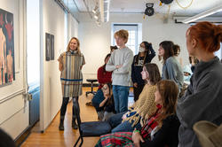 Mimi Cabell and students gather around a painting during crit