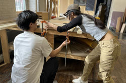 two students work together in the BEB wood shop to glue up a jig
