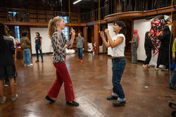 Students stand facing each other in a classroom as they play a game