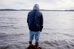 a fully dressed man walking out into the sea