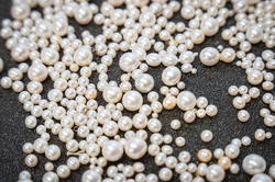 a pile of pearls on a black tray