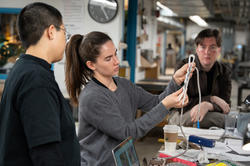 a student shows the group how she intends to wire her bobby pin lamp in progress