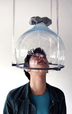 a sculpture by Glass alum Yiyi Wei hovers over the head of a student