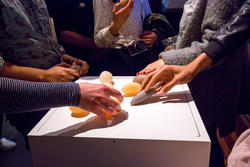 Student hands touching objects on a table.