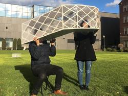 students peer through a built structure by Interior Architecture alums Bryant Liu and Ashley Chen