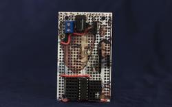 Student work by Brian Oakes BFA 2018. An electrical board with the faces of men painted onto it.