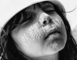Student work by Maria Bedoya BFA 2017. Closeup black and white image of a young girl with closed eyes.