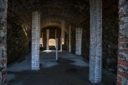 Student work by Minhee Kang BFA 2017. A dark corridor is decorated with large columns of white see-through fabric.