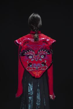 Student work by Yan Zeng MFA 2017. A model wearing a custom designed red jacket with a large embroidered tiger's face on the back.
