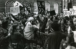 A group of protestors holding raised signs