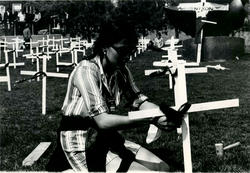 Person in a graveyard installing a cross