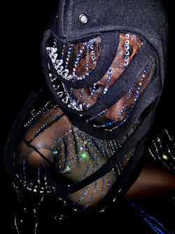 a model wears a shear black garment and denim head covering designed by Kylin Conant