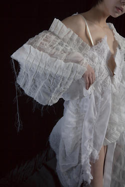a model wears a shear white garment designed by Avery Albert