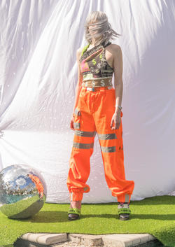 a model in orange pants and tank top featuring dollar signs, designed by Isabelle Saxton