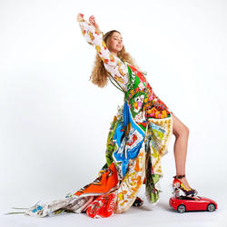a model wears a multicolored dress that flows behind them, designed by Zoe Grinfeld