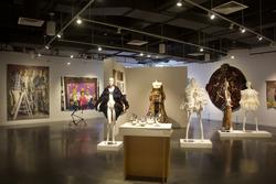 apparel designs dressed on five mannequins among other works in a gallery
