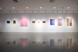 a row of paintings on a Memorial Gallery wall