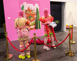 Students dressed in pink knitted ski masks prepare to perform at Grad Show 2023