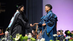 President Crystal Williams shakes the hand of a graduating student at Commencement 2023