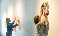 Experimental and Foundation Studies students pin work to the wall in preparation for spring crits