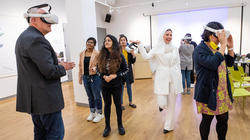 students help visiting faculty members access design presentations via VR headsets