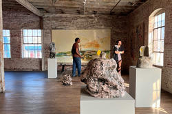 Students walk through the bright gallery and studio of RISD alum, Elliot Hundley 97 PR. 