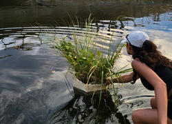 Student researcher floats biopod in the river