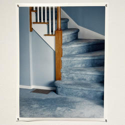 Sarah Meftah's "Vertical Hallway" shows the base of a stairwell with blue walls and blue carpet