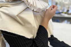 Maya Muravlev touches a fabric ribbon collar that she made