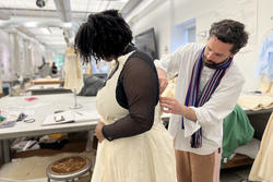 Gwen van den Eijnde helps sophomore Paige Sias sew her garment