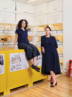 Jonsara Ruth at left sitting on a table with her cofounder of the Healthy Materials Lab.