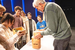 students and faculty member Peter Dean examine a wooden cabinet during final crits