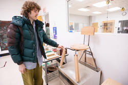 Cam Lasson demonstrates the mix-and-match chair he created for the exhibit