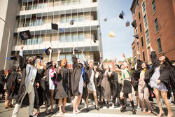 2021 graduates tossing their hats