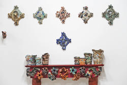 Colorful ceramic pieces hung on wall and mantel