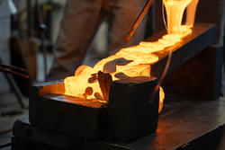 Molten glass pours down slanted blocks