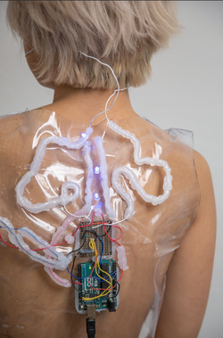 a wired device affixed to a person's bare back