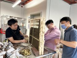 three students working on a large brick structure