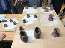 numerous clay vessels sitting on a studio table
