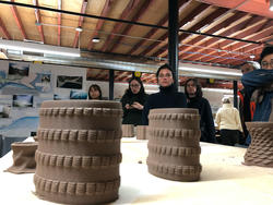 students look at clay sculptures on a studio table
