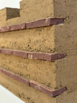 detail of three thin layers of brick inserted into a large block of earth