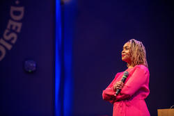 Jameka Hartley stands in an auditorium on stage