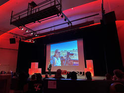 A presenter on stage gives a speech at TEDxRISD event